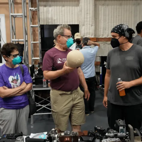 People talking to each other at an indoor yard sale. 