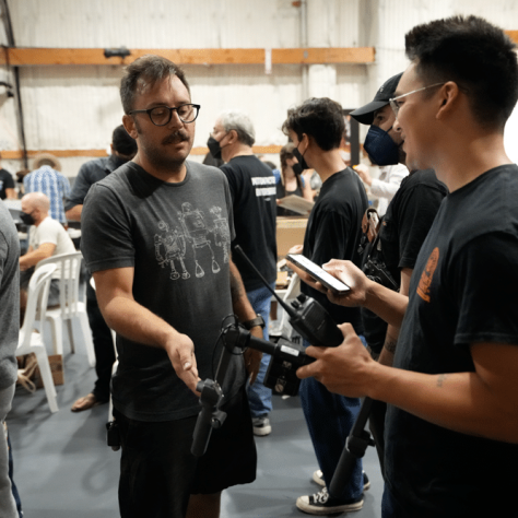 People talking to each other at an indoor yard sale. 