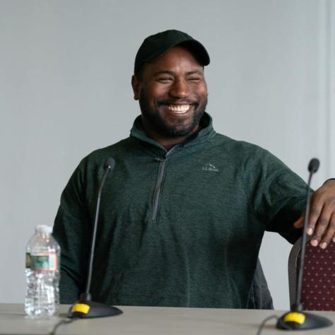 Man smiling at a table. 