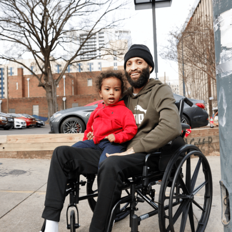 Man posing with child in lap. 