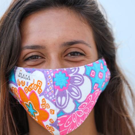 Close up of woman wearing colorful mask. 