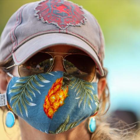 Close up of woman in a hat and colorful mask. 