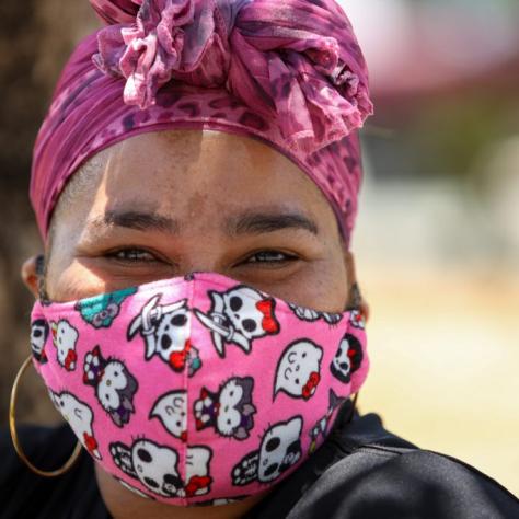 Close up of woman in pink head wrap and pink mask. 