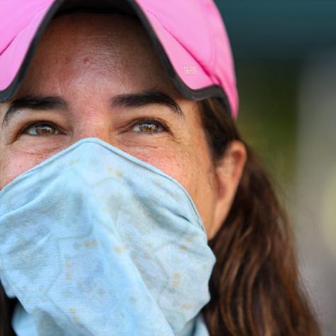 Close up of woman in pink hat and blue mask. 