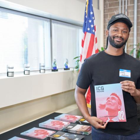 Man posing with book for photo at party.