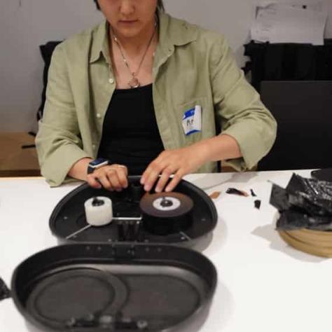 Woman sitting at a table working with film. 