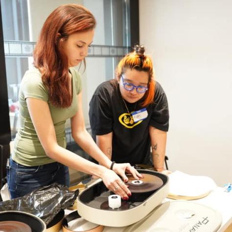 Two people standing at a table working with film. 