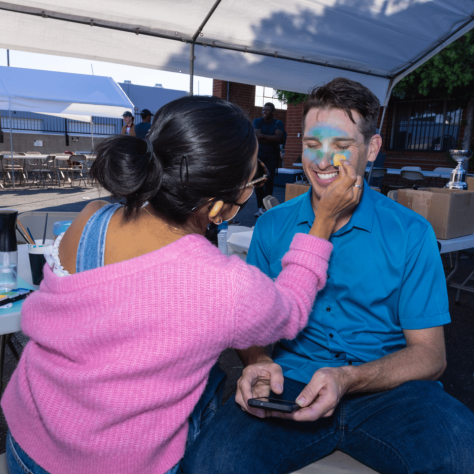 Man getting facepaint. 