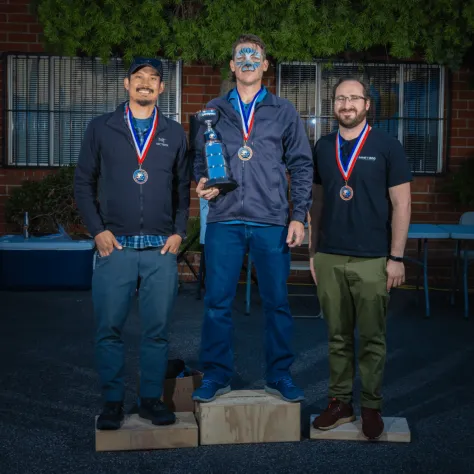 Three people with medals on podium. 