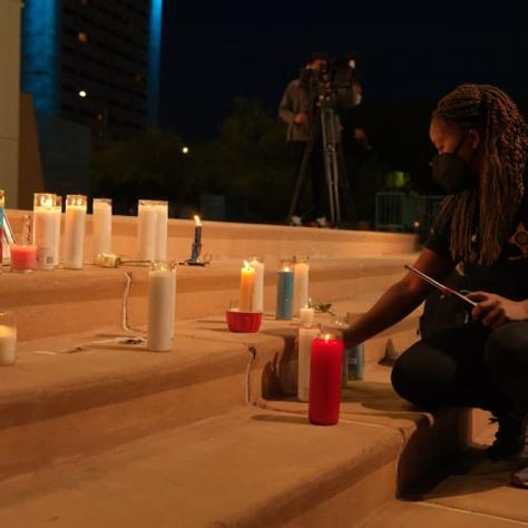 Someone lighting a candle on steps. 