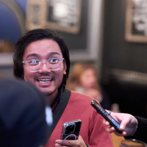 Man with glasses smiling. 