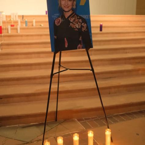 Photo of a woman with candles lit around it. 