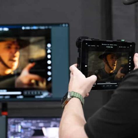 Man holding a screen and screen in background. 