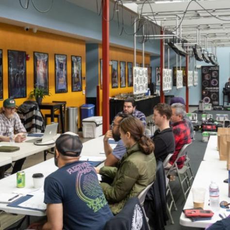 People sit at tables listening to an instructor