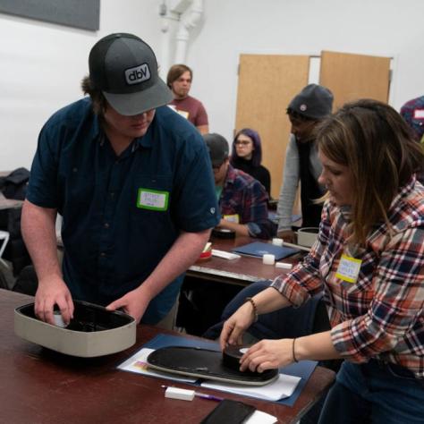 A man and a woman assembling a film loader