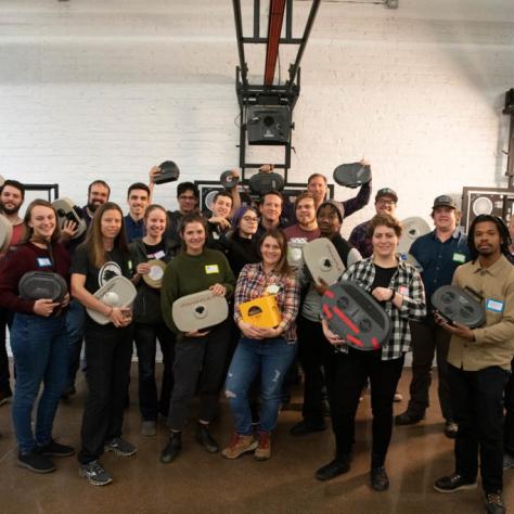 Group of people pose for a photo holding film loaders