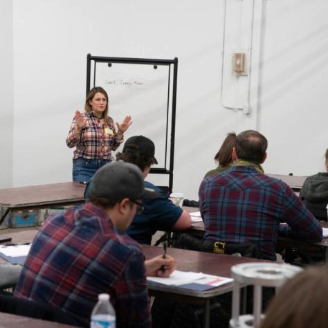 Woman presents in front of students